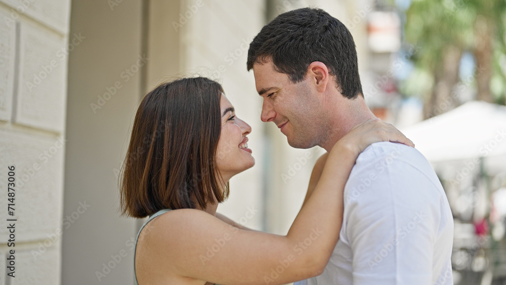 Beautiful couple smiling confident standing together looking each other at street
