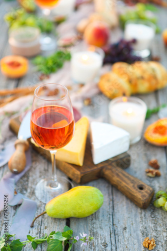 One glass of rose wine on table with fruits and cheese