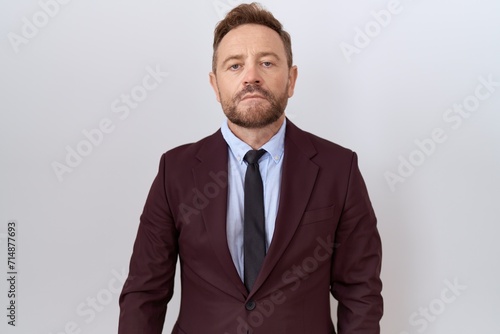 Middle age business man with beard wearing suit and tie relaxed with serious expression on face. simple and natural looking at the camera.