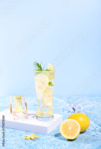 fresh lemon water in glass with lemon slices fruits on sea beach with. Summer sea vacation and travel concept. Exotic summer drinks.