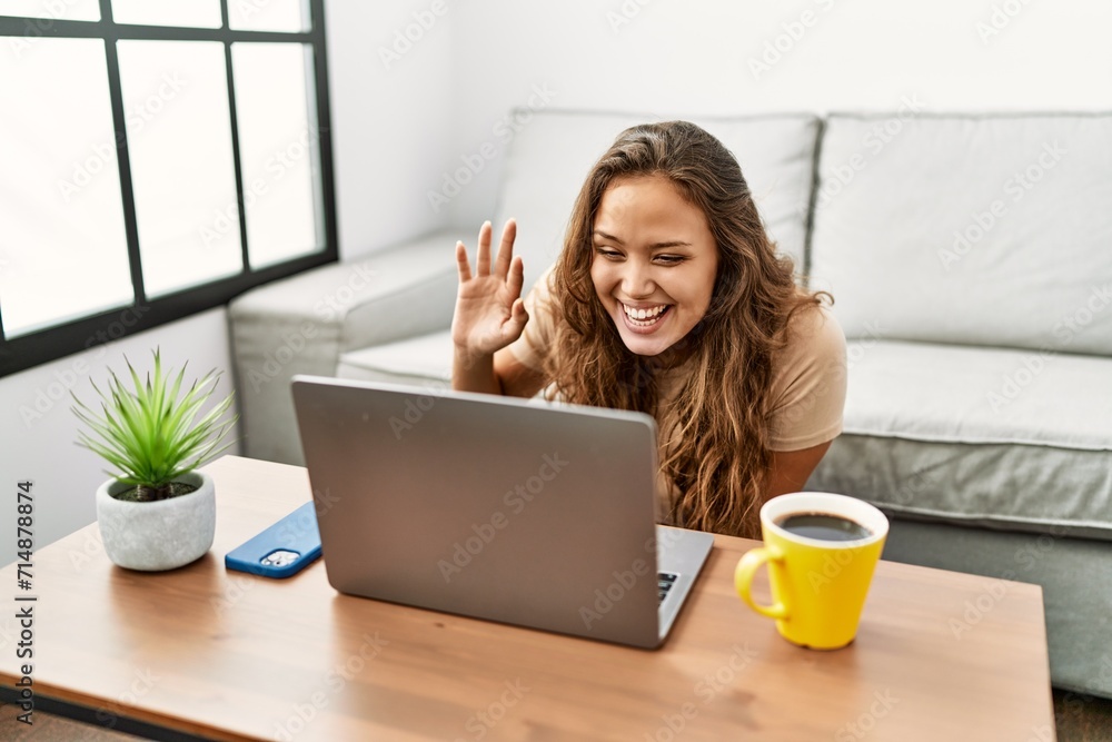 Young beautiful hispanic woman having video call sitting on floor at home Young beautiful hispanic woman having video call sitting on floor at home