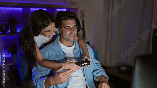 A woman and a man enjoy gaming together in a dark  cozy room at night  highlighting their relationship and leisure time.