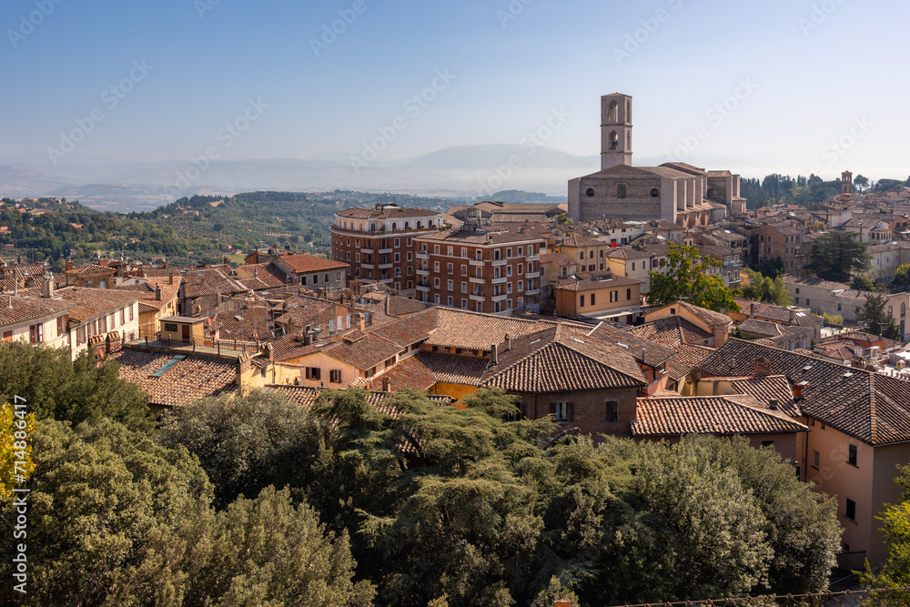 Ancient Italian town on hill with tiled roofs of buildings, church and bell tower, Perugia, Italy