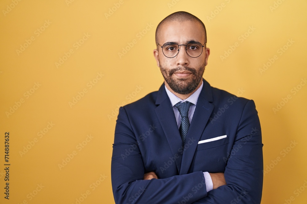 Hispanic man with beard wearing suit and tie skeptic and nervous, disapproving expression on face with crossed arms. negative person. Hispanic man with beard wearing suit and tie skeptic and nervous, disapproving expression on face with crossed arms. negative person.
