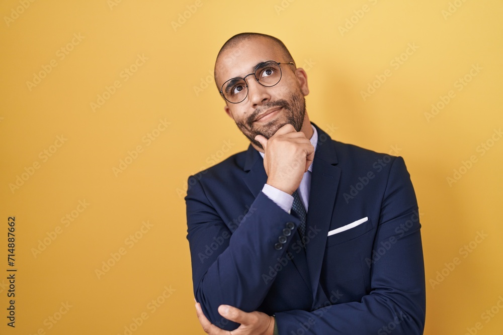 Hispanic man with beard wearing suit and tie looking confident at the camera smiling with crossed arms and hand raised on chin. thinking positive. Hispanic man with beard wearing suit and tie looking confident at the camera smiling with crossed arms and hand raised on chin. thinking positive.