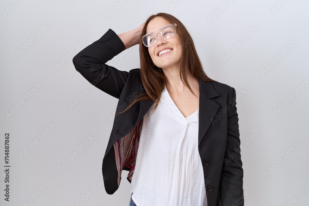 Beautiful brunette woman wearing business jacket and glasses smiling confident touching hair with hand up gesture, posing attractive and fashionable Beautiful brunette woman wearing business jacket and glasses smiling confident touching hair with hand up gesture, posing attractive and fashionable