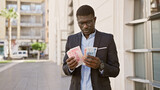African man in business attire counts chinese yuan on an urban street.