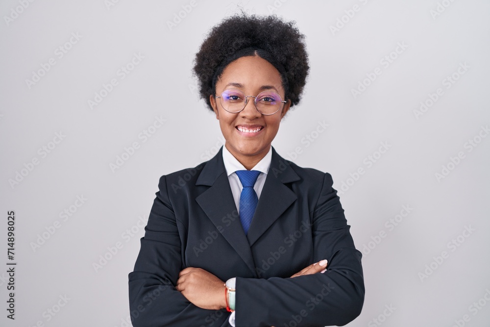 Beautiful african woman with curly hair wearing business jacket and glasses happy face smiling with crossed arms looking at the camera. positive person. Beautiful african woman with curly hair wearing business jacket and glasses happy face smiling with crossed arms looking at the camera. positive person.