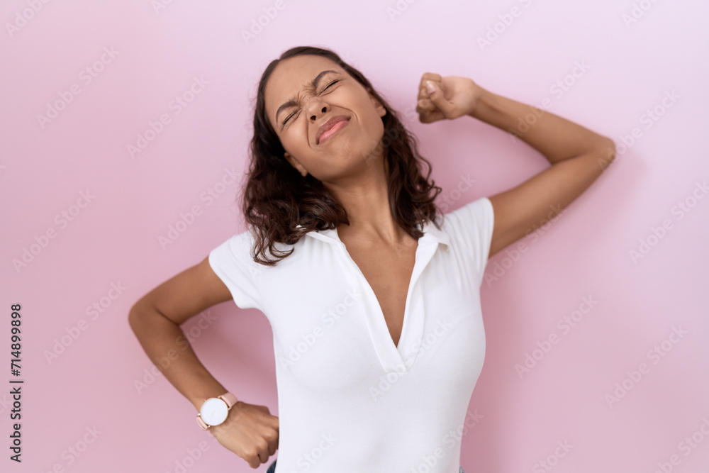 Young hispanic woman wearing casual white t shirt stretching back, tired and relaxed, sleepy and yawning for early morning Young hispanic woman wearing casual white t shirt stretching back, tired and relaxed, sleepy and yawning for early morning