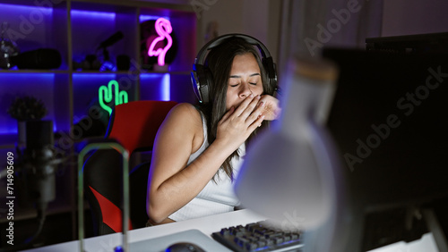 Young beautiful hispanic woman streamer tired using computer at gaming room