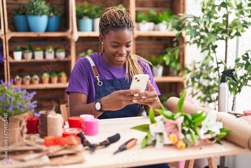 African american woman florist smiling confident using smartphone at florist photo