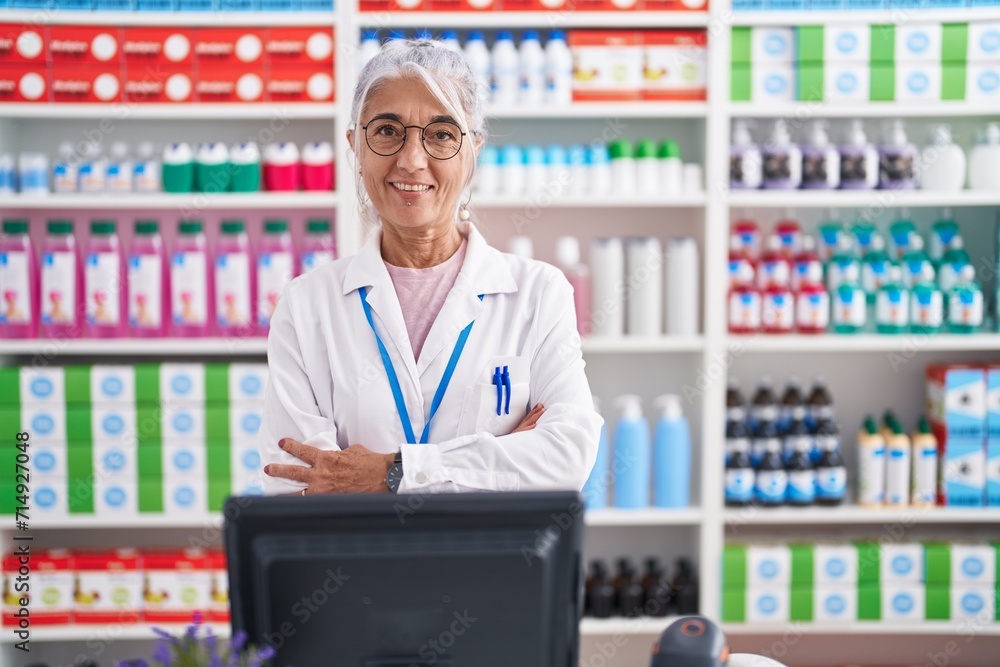 Middle age woman with tattoos working at pharmacy drugstore happy face smiling with crossed arms looking at the camera. positive person. Middle age woman with tattoos working at pharmacy drugstore happy face smiling with crossed arms looking at the camera. positive person.