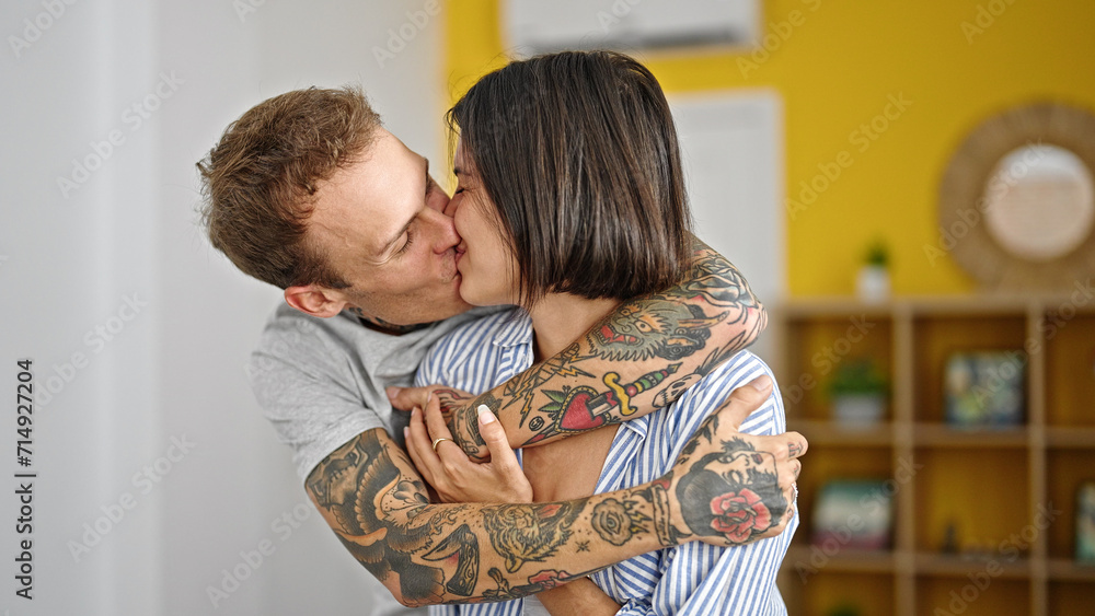Beautiful couple hugging each other kissing at home