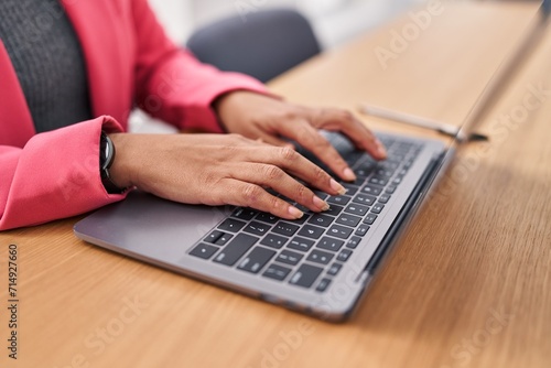 Young beautiful hispanic woman using laptop working at office