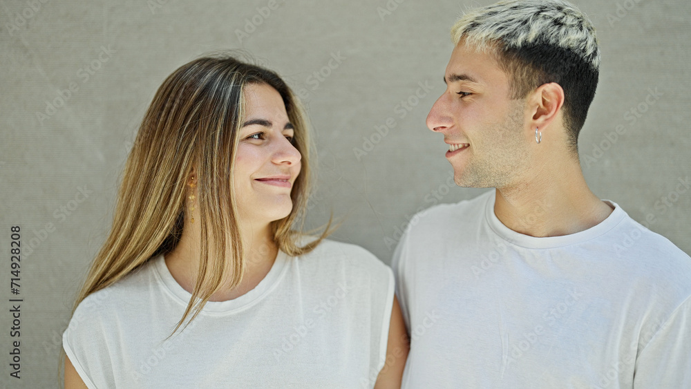 Beautiful couple smiling confident looking each other over isolated white background Beautiful couple smiling confident looking each other over isolated white background