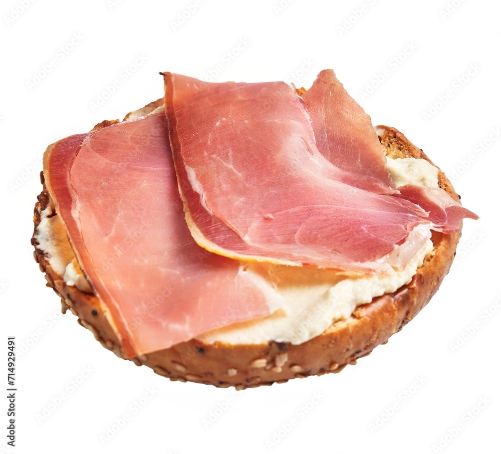 Wholegrain bagel topped with cream cheese and slices of prosciutto isolated on white