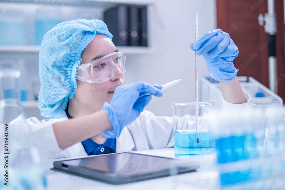 Fototapeta premium Professional woman specialist doctor laboratory white uniform use thermometer temperature on blue liquid in healthcare and medicine experiment equipment with glove care, young adult female scientist