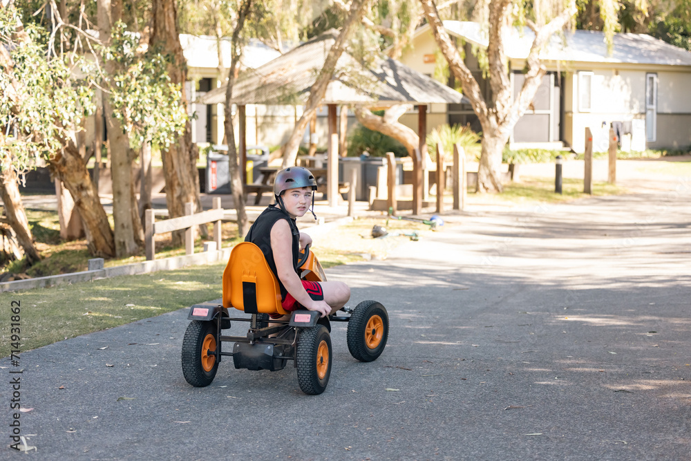 Boy riding pedal cart on caravan park holiday Boy riding pedal cart on caravan park holiday