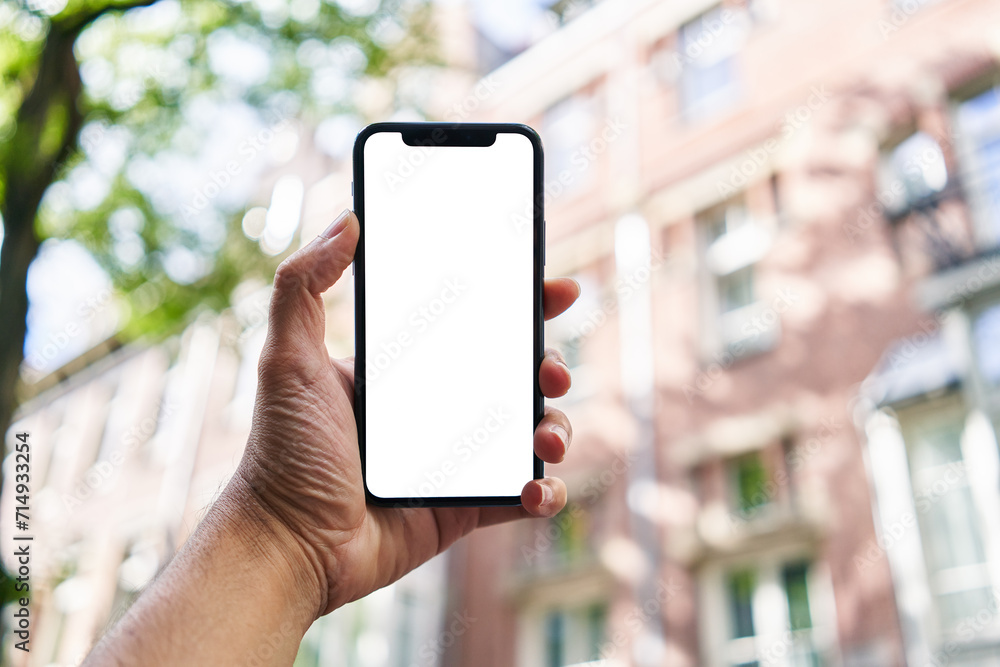 Man holding smartphone showing white blank screen at street Man holding smartphone showing white blank screen at street