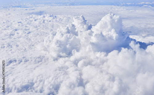 Aerial view of fluffy white cumulus clouds from above, symbolizing nature's tranquility and the beauty of earth's atmosphere.