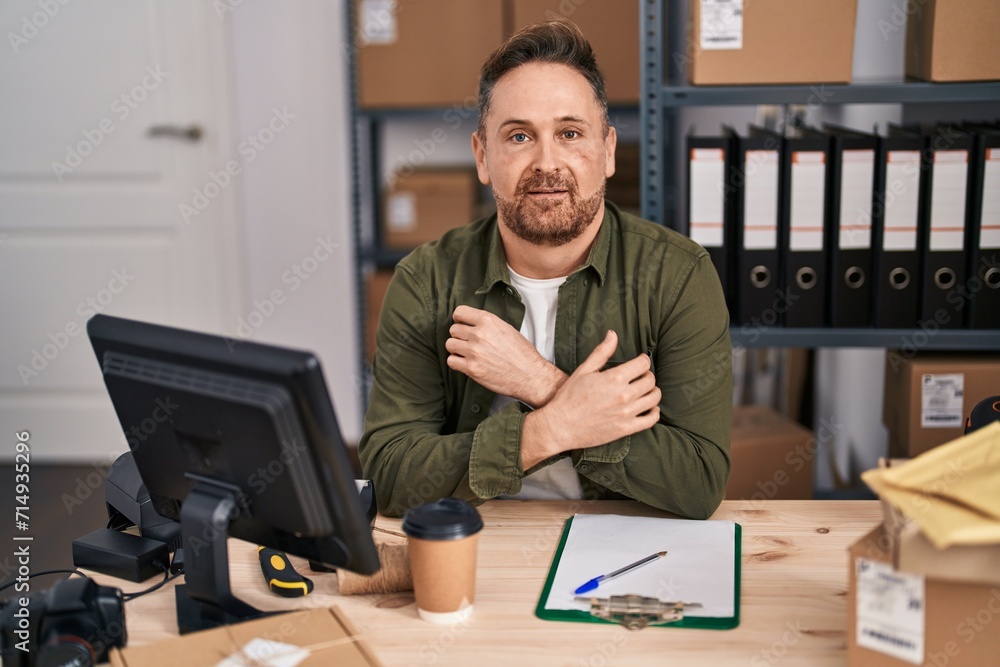 Young caucasian man ecommerce business worker sitting on table with relaxed expression at office Young caucasian man ecommerce business worker sitting on table with relaxed expression at office