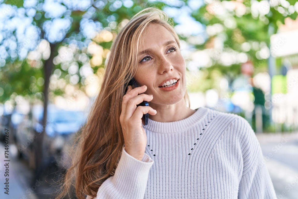 Young blonde woman smiling confident talking on the smartphone at street Young blonde woman smiling confident talking on the smartphone at street