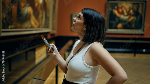 Canvastavla Young beautiful hispanic woman visiting art gallery using smartphone at Art Muse