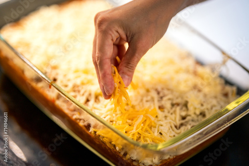 adding cheese on top of lasagna photo