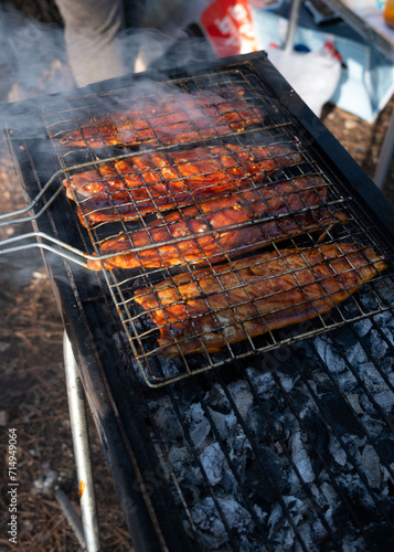 Smoky flavor infuses mackerel fillets as they char-grill on a wire rack, in the tranquil Beit Shemen forest near Jerusalem, under the golden light of sunset photo