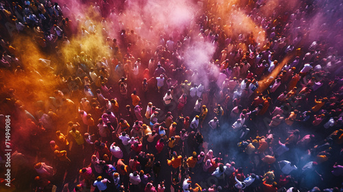 An overhead shot of a Holi festival in full swing  with crowds of people dancing  throwing colors  and celebrating amidst a sea of colorful powders. The aerial perspective captures