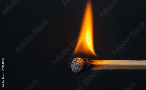 Burning wooden match on black background.