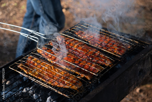 Smoky flavor infuses mackerel fillets as they char-grill on a wire rack, in the tranquil Beit Shemen forest near Jerusalem, under the golden light of sunset photo