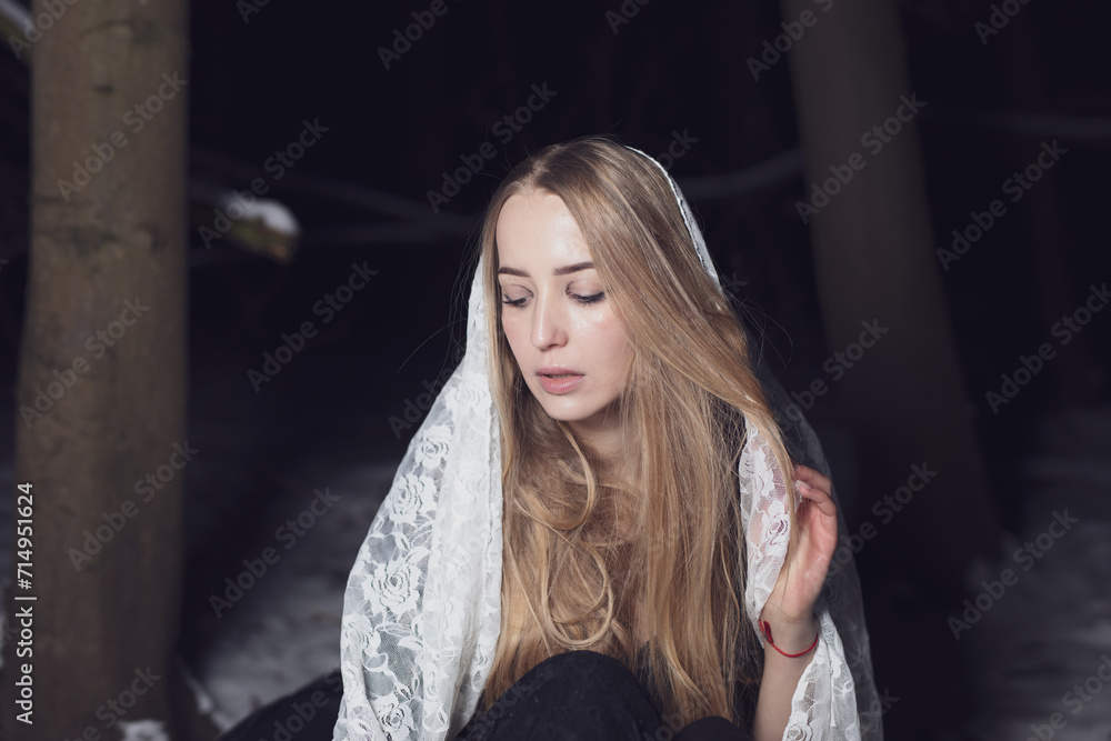 Fototapeta premium young blond woman with blue eyes dancing in the dark night of an very cold snow winter