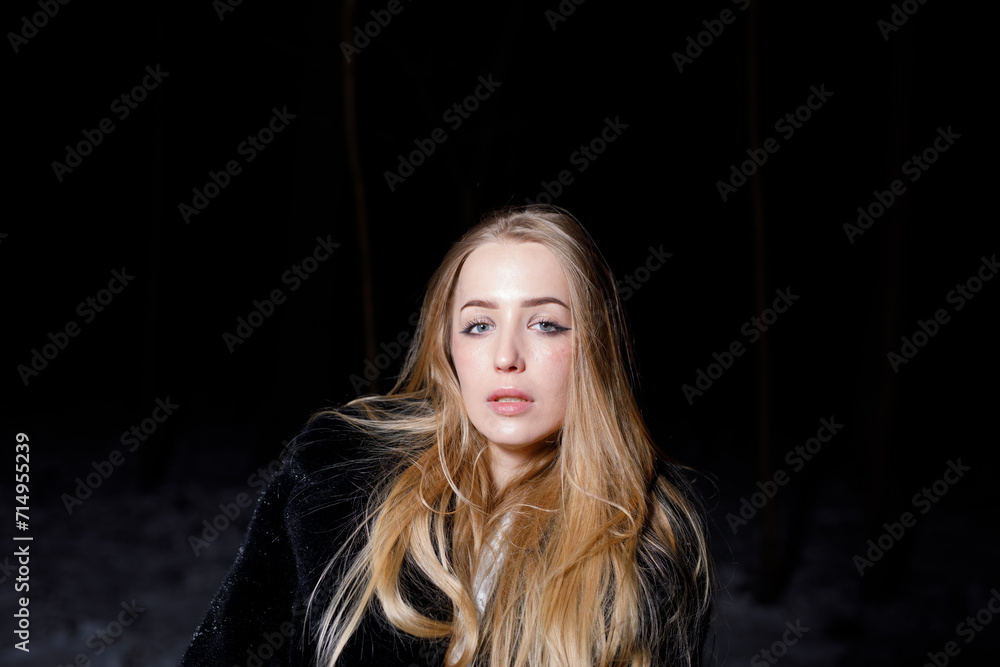 young blond woman with blue eyes dancing in the dark night of an very cold snow winter young blond woman with blue eyes dancing in the dark night of an very cold snow winter