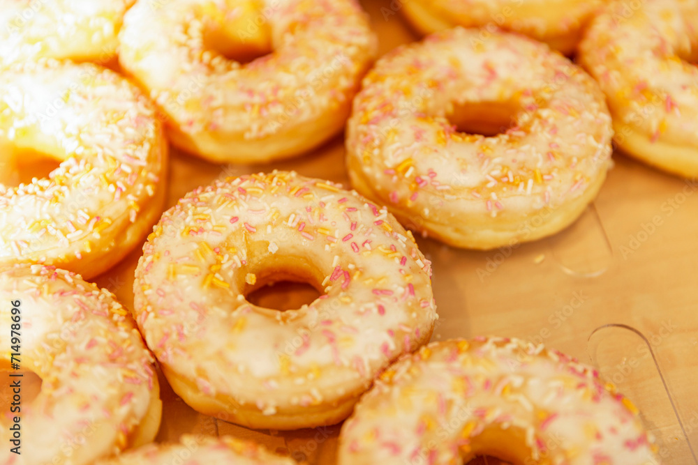 Many donuts with yellow icing on the counter in a store. Traditional mouth-watering sweets. Close-up.