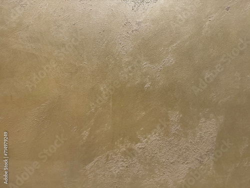 Gold or golden textured paint washed on a wall or panel, seamless texture, random texture. No people