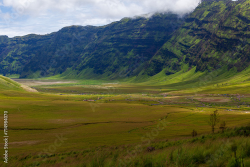 Landscape of green hills in the mountains on a cloudy day. Location of Mount Bromo in Bromo Tengger Semeru National Park  East Java  Indonesia