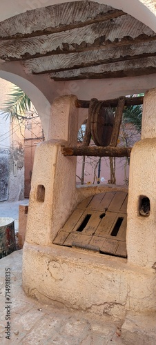 a traditional and ancient well in LES KSOURS DU M’ZAB. made of clay , wood, and stones, typical sub-Saharan desert architecture, Ghardaïa, Oasis M'zab, Algeria photo