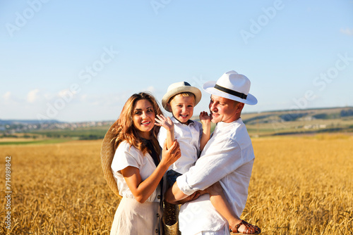 Happy family with happy son in the summer sunset field