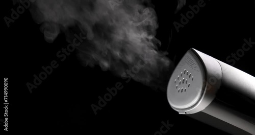 clothes steamer blowing steam on black background photo