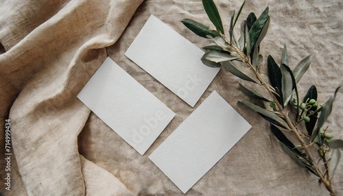 wedding stationery still life concept set of blank cotton paper business place cards or invitations mockups olive tree branch on beige linen table cloth background minimal flat lay top view