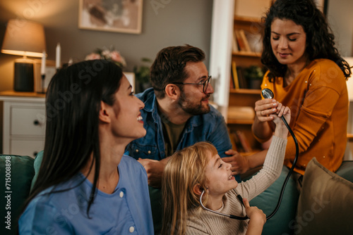 A family cherishing the joyous scene of their daughter playfully examining a home nurse with a stethoscope
