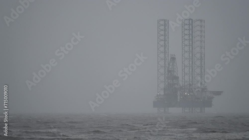 Gas rig situated off Ainsdale beach on cloudy and stormy day photo
