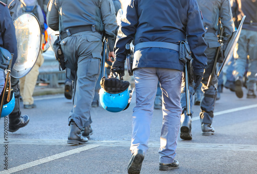 policemen in uniform with riot gear during the protest demonstration with helmets and shields