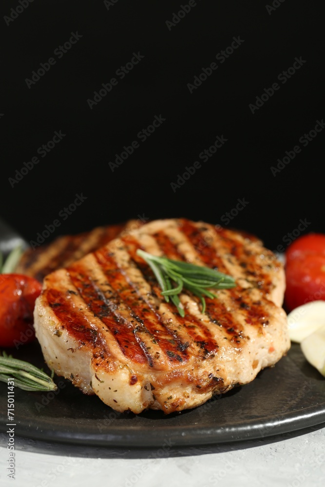 Delicious grilled pork steaks with spices on table against black background, closeup. Space for text Delicious grilled pork steaks with spices on table against black background, closeup. Space for text