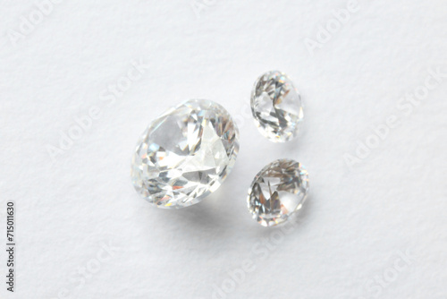 Beautiful shiny diamonds on white background, flat lay