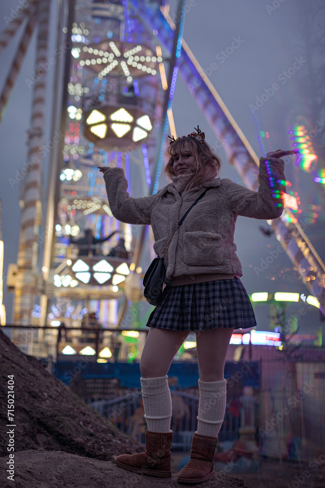 young cosplay woman on fun fare and Ferris wheel with magic winter lights