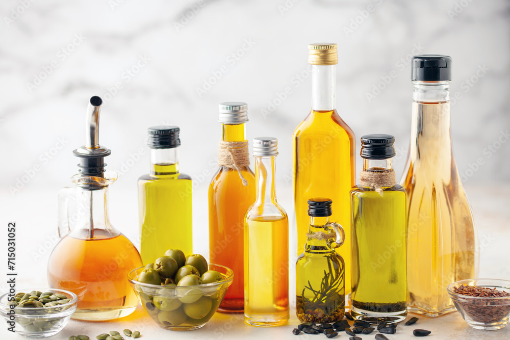 Various vegetable and seed oil in bottles on a bright background.