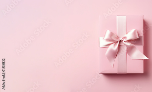 pink gift box with ribbon on minimal background copy space left. Birthday, Valentines Day, Mother's Day celebration banner. © Dina