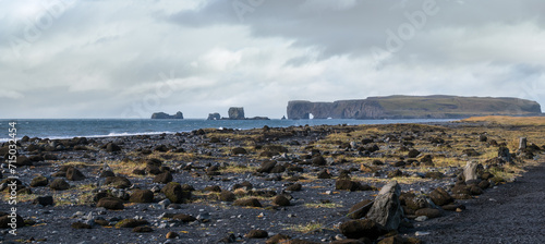 Picturesque autumn Dyrholaey Cape and  rock formations view from Reynisfjara ocean black volcanic sand beach. Vik, South Iceland.